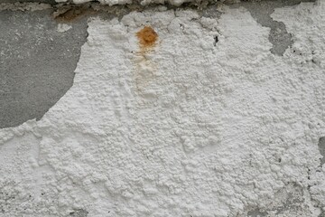 Wall surface with peeling, cracked and damaged white paint, damp wall with damaged white paint