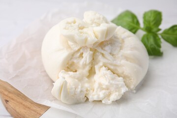 Delicious fresh burrata cheese on white table, closeup