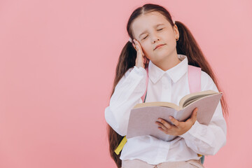 Beautiful little girl in school uniform reading a book stressed and frustrated with hand on head...