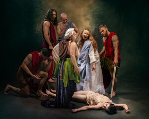 People in ancient-style robes stand around a woman lying on the ground. Group appears to be discussing or judging the situation Concept of comparisons of eras, social issues and condemnation.