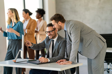 Multicultural professional businesspeople working together on research plan in boardroom.