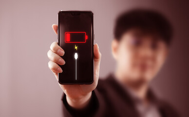 Smartphone's battery power is running low with a virtual low battery symbol warning on the screen....