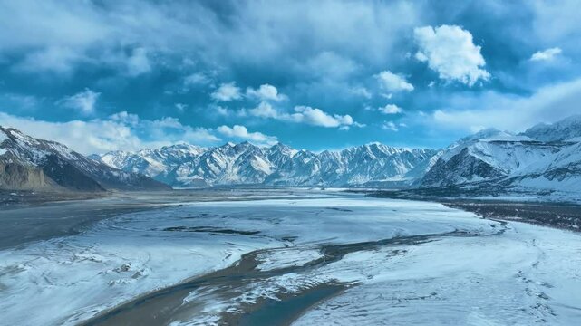 Wide angle view of snow covered range of mountains at Skardu during daytime in Pakistan. Cloudscape, Aerial shot.