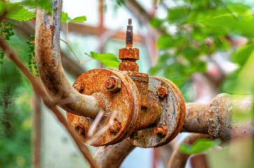 Rusty metal pipe, old water faucet in abandoned building