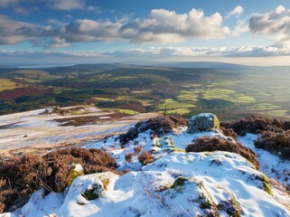 View from the top of Black Clover Mountain in Yorkshire, overlooking a green valley with some snow on heather and other flowers, a blue sky, late afternoon