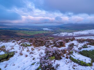 View from the top of Black Clover Mountain in Yorkshire, overlooking a green valley with some snow on heather and other flowers, a blue sky, late afternoon