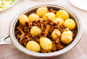 Delicious fried chanterelles with new potatoes in a frying pan