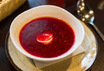 Beetroot soup with sour cream in bowl