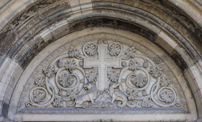 Verzierung über einer Kirchentür mit Kreuz und zwei Löwen