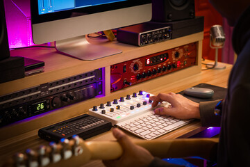 back of male musician recording electric guitar track in home studio