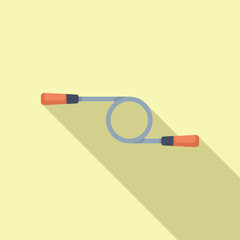 Skipping rope is lying on a yellow background, casting a long shadow