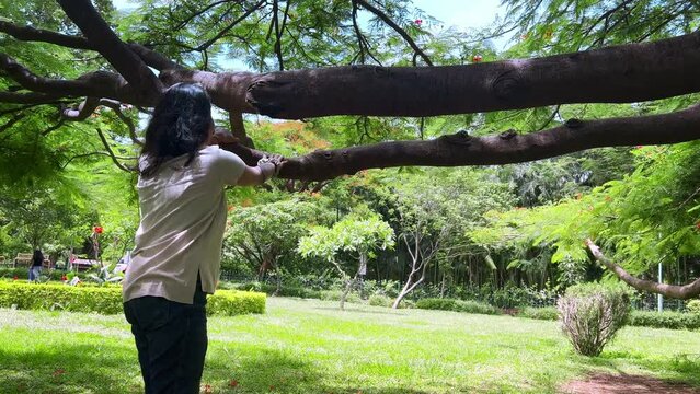 Young Indian woman relaxing and enjoying in cubbon park in a white shirt and jeans in Bangalore, india