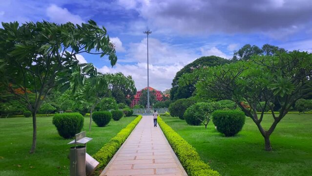 Young Indian woman walks along the path in the cubbon park in a white shirt and jeans in Bangalore, india
