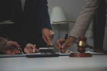 Judge gavel with Justice lawyers having team meeting at law firm background. Concepts of Law and...
