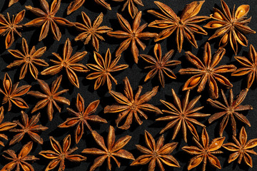 Anise stars texture pattern, above view close up flavor spices dried anise seeds on dark background still life with natural condiments, aromatic ingredient for cooking drink and food