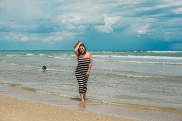 Woman with a dog at the beach, concept of pets. Pet owner playing outside