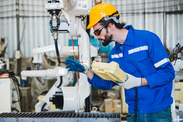 engineer controlling robot arm at factory. checking the operation of robot arm. Technology, automation, innovation and engineering concept.