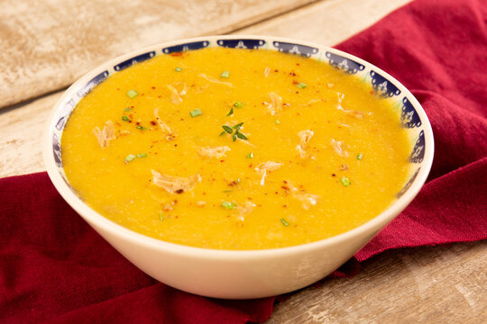 Creme de mandioca com frango desfiado, ervas frescas e pimenta calabresa vista isom&eacute;trica