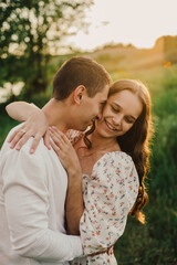 Fototapeta premium A married couple in a field of wheat at sunset in the afternoon.
