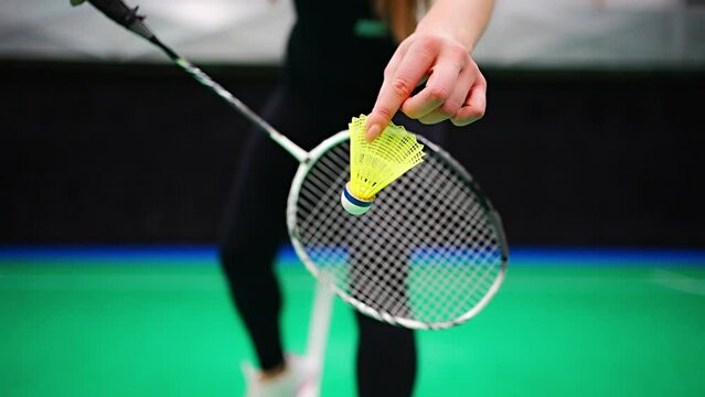 Close up view of racket and shuttlecock, practicing serve before playing in badminton on inside court