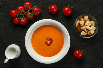 tomato cream soup in white bowl on black desk