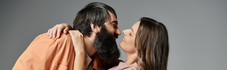 Fototapeta premium A couple in sophisticated attire shares a tender moment, their eyes locked in love.