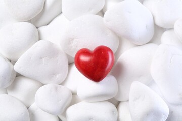 Decorative heart on white pebble stones, top view