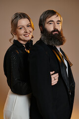 A couple dressed in sophisticated attire poses for a portrait.