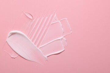 Samples of face cream on pink background, top view. Space for text