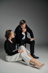 Obraz premium A couple dressed in sophisticated attire poses together, creating a captivating image of intimacy and connection.