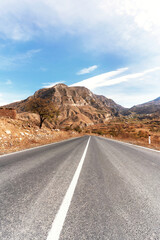 Road in serene mountain landscape bathed in the warm tones of red and yellow.