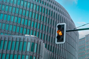 Traffic Light With Amber Signal In Front Of Modern Building