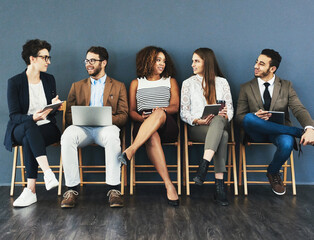 Discussion, technology and business people in waiting room for interview, meeting or recruitment on chair. Hiring, HR and diversity candidates in office for opportunity, onboarding or employment