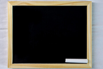Black school blackboard and chalk next to it. Top view. For backgrounds and presentations