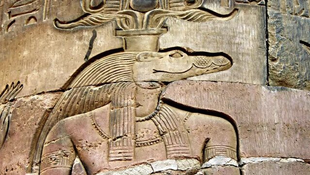 Crocodile head depicting an ancient Egyptian mythological god carved on wall of Kom Ombo temple near Aswan
