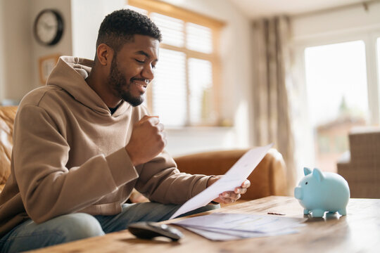 Man Reviewing Financial Documents With Piggy Bank on Table