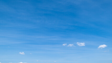 Fototapeta premium clear blue sky background,clouds with background, Blue sky background with tiny clouds. White fluffy clouds in the blue sky. Captivating stock photo featuring the mesmerizing beauty of the sky and cl