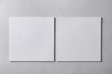Blank paper sheets on grey textured background, top view. Mockup for design
