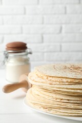Stack of tasty homemade tortillas on white table
