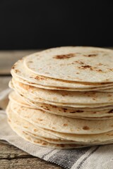 Stack of tasty homemade tortillas on wooden table