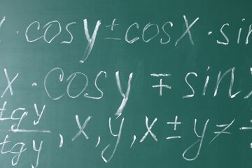 Many different math formulas written on chalkboard