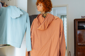 Teenager girl looking at clothes in wardrobe