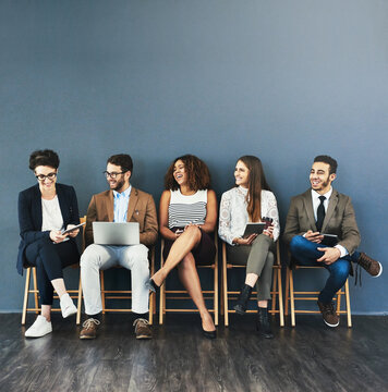 Business people, technology and conversation in waiting room for interview, meeting or recruitment on chair. Hiring, HR and diversity candidates in office for opportunity, onboarding or employment