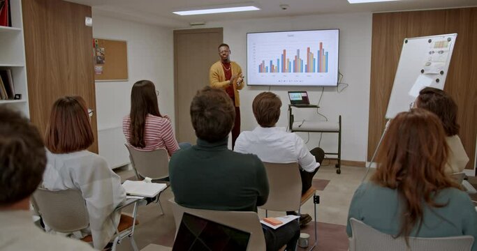 Employees from different generations gather in a modern classroom, eagerly absorbing knowledge during a sales training or seminar, bridging generational gaps and enhancing their skills together.