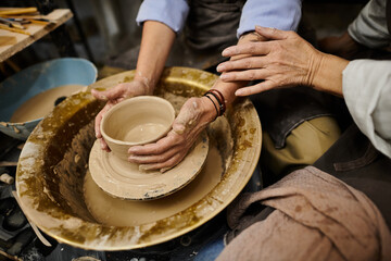 A close-up of a mature lesbian couple working on pottery in a cozy studio setting.
