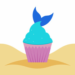 A cupcake with sparkling blue frosting and a mermaid tail topper rests on a sandy beach