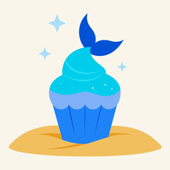 A cupcake with sparkling blue frosting and a mermaid tail topper rests on a sandy beach