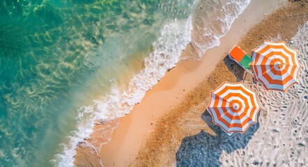 Naklejka premium An aerial view of beach chairs and umbrellas on sand near the ocean, with green foliage in the background. Shading effects on the sand appear as light and shadow play with each other. A summer