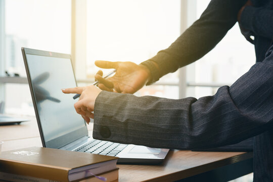 Female and Male Hands pointing at laptop screen on desk in coworking