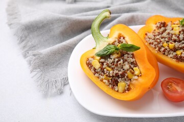 Quinoa stuffed bell pepper with basil and tomato on light table, closeup. Space for text